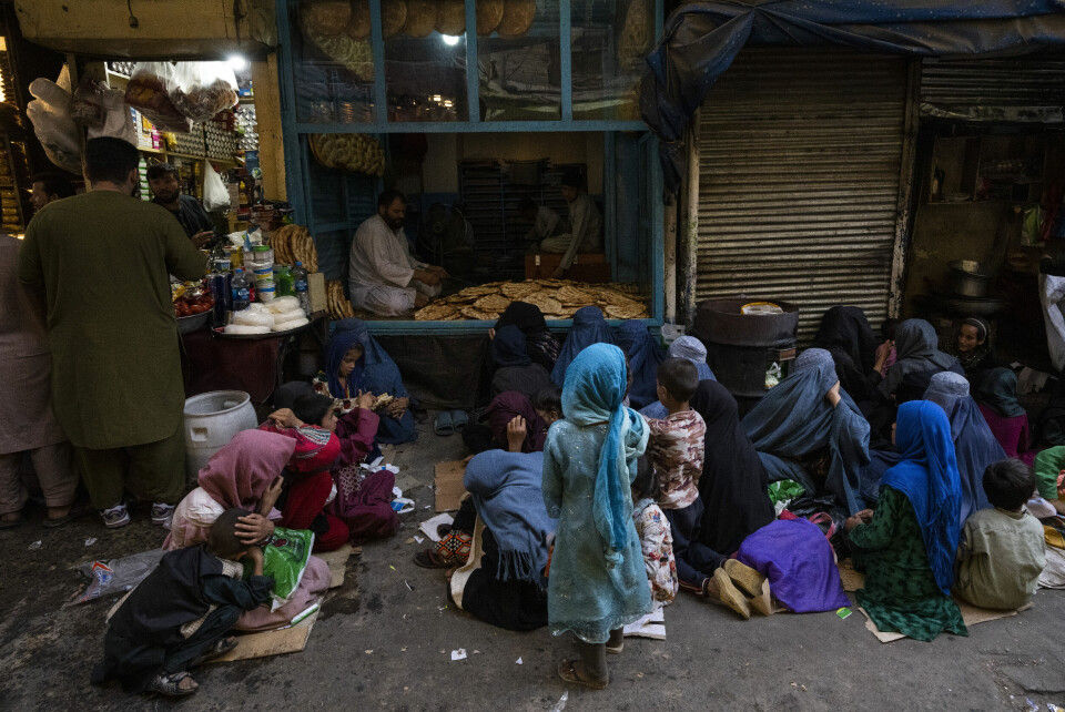 Afghanske kvinner og barn sitter utenfor et bakeri i Kabul og venter på gratis brød. Afghanske kvinner og barn sitter utenfor et bakeri i Kabul og venter på gratis brød.