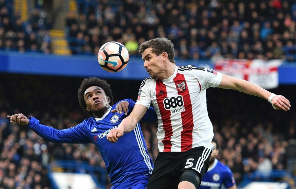 Brentford-forsvarer Andreas Bjelland er en av flere dansker på laget. Han har norsk far, men spiller for Danmark, sist sett da Danmark feide Irland av banen i VM-play offen i Dublin tirsdag. Her i duell med Chelseas Willian i FA-cupkamp som byrivalen vant 4-0. FOTO: GLYN KIRK/NTB SCANPIX