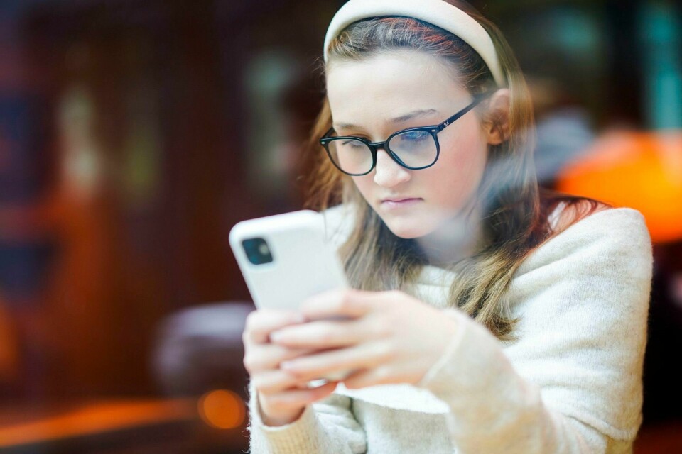Mobilbruk og KI i skolen er to ulike diskusjoner. Med mindre man ønsker å fjerne alle PC-er og nettbrett i skolen, må det være rom for å diskutere hva man skal bruke de digitale læremidlene til, skriver forfatterne av innlegget. Ung jente med mobiltelefon