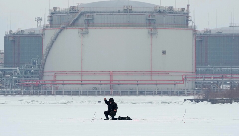 De russiske kuttene kommer på toppen av tidligere kutt i både produksjon og eksport av olje fra noen av verdens største produsenter. Bildet viser en isfisker med oljelagringstanker i havnen i St. Petersburg i bakgrunnen i februar. De russiske kuttene kommer på toppen av tidligere kutt i både produksjon og eksport av olje fra noen av verdens største produsenter. Bildet viser en isfisker med oljelagringstanker i havnen i St. Petersburg i bakgrunnen i februar. Foto: Dmitri Lovetsky / AP / NTB