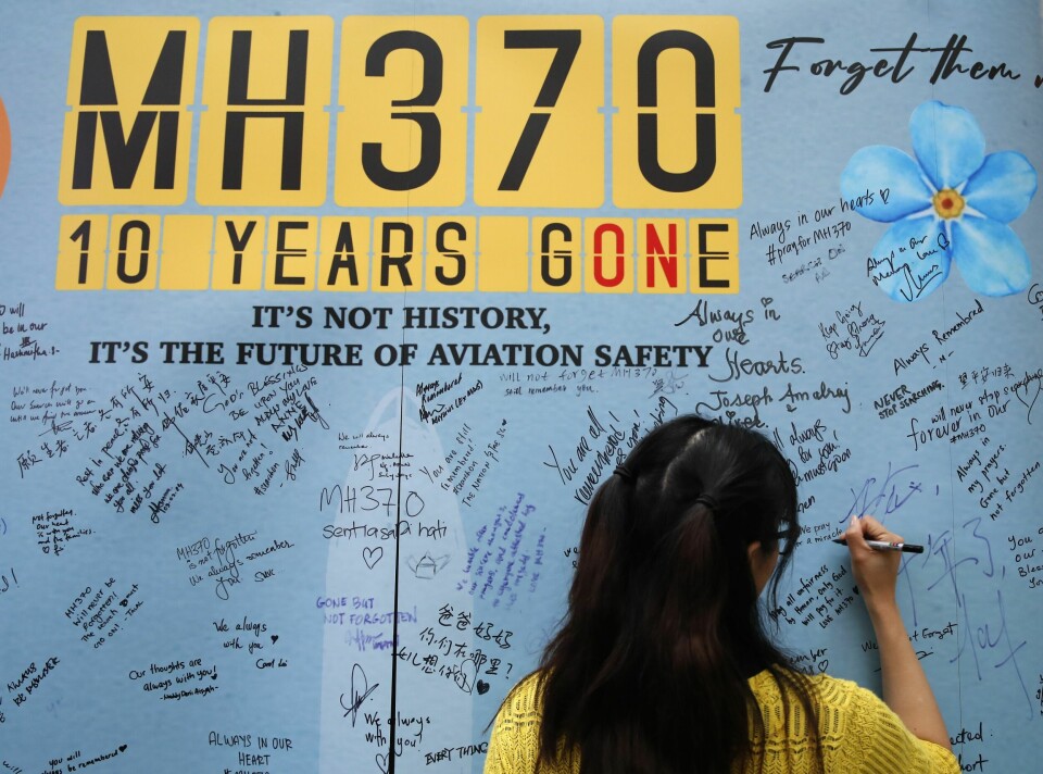 En kvinne skriver en hilsen på en minnevegg i anledning at det er ti år siden passasjerflyet MH370 forsvant sporløst kort tid etter avgang fra Kuala Lumpur. En kvinne skriver en hilsen på en minnevegg i anledning at det er ti år siden passasjerflyet MH370 forsvant sporløst kort tid etter avgang fra Kuala Lumpur. Foto: FL Wong/AP/NTB