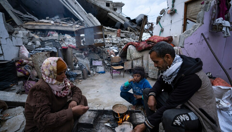Palestinere lager mat i Rafah sør på Gazastripen, omgitt av bygninger ødelagt i israelske angrep. Maten har tatt slutt for mange av palestinerne på Gazastripen, men nødhjelpen utenfra lar vente på seg. Foto: AP / NTB