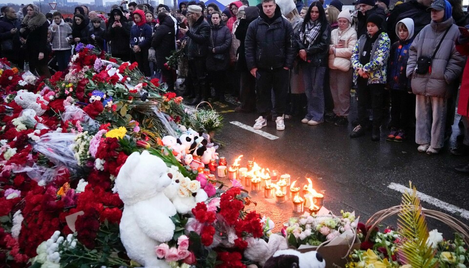 Folk samlet seg lørdag for å legge ned blomster og tenne lys utenfor konsertlokalet Crocus. Folks samlet seg ved konserthallen Crocus i den vestlige utkanten av Moskva lørdag for å hedre ofrene for terrorangrepet kvelden før. Foto: Aleksander Zemlianitsjenko / AP / NTB