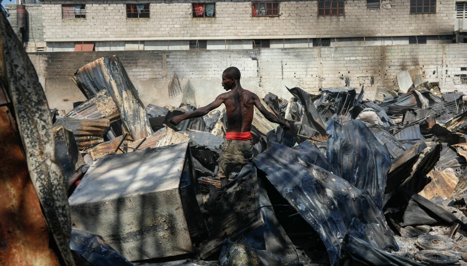 En mann søker gjennom ødelagte gjenstander på et bilverksted i Port-au-Prince som ble satt i brann. Haiti er rammet av en blodig gjengkrig. En mann søker gjennom ødelagte gjenstander på et bilverksted i Port-au-Prince som ble satt i brann. Haiti er rammet av en blodig gjengkrig. Foto: Odelyn Joseph / AP / NTB