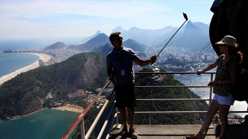 En mann tar en selfie med mobiltelefon på en selfiestang på toppen av Sukkertoppen i Rio de Janeiro. FOTO: ERIK JOHANSEN/NTB SCANPIX En mann tar en selfie med mobiltelefon på en selfiestang på toppen av Sukkertoppen i Rio de Janeiro. FOTO: ERIK JOHANSEN/NTB SCANPIX