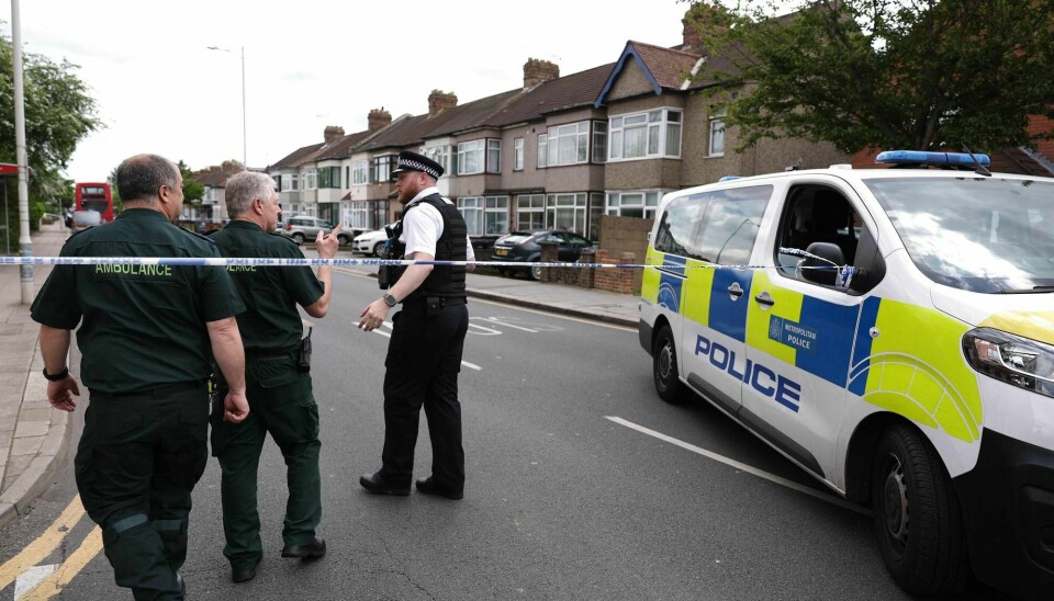 En politimann snakker med ambulanse-personale etter at en mann angrep flere personer med et sverd i Hainault øst i London tirsdag. A Police officer speaks to ambulance staff at a crime scene in Hainault, east of London on April 30, 2024 where a 36-year-old man wielding a sword was arrested following an attack on members of the public and two police officers. A man with a sword was arrested in Hainault, east of London, after several people were attacked and injured, the Metropolitan Police said on Tuesday.The force said it was called just before 7:00 am (0600 GMT) after a vehicle drove into a house and reports that 'people have been stabbed'. (Photo by Adrian DENNIS / AFP)