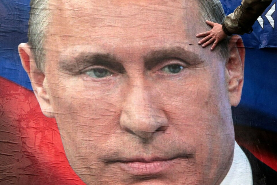 Man bør ikke fokusere for mye på mistilliten mellom Moskva og Kyiv, ifølge analytiker Samuel Charap. A man finishes glueing huge placards bearing images of Russian President Vladimir Putin in the city centre of Simferopol, Crimea, on March 4, 2022. - Ukraine accused the Kremlin of 'nuclear terror' on March 4, after Europe's largest atomic power plant was attacked and taken over by invading forces, sparking Western horror at the threat of Russia's war contaminating all of Europe. (Photo by STRINGER / AFP)