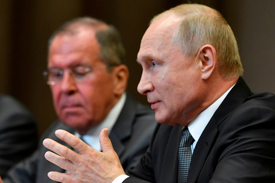 Russlands president Vladimir Putin. Utenriksminister Sergej Lavrov skimtes i bakgrunnen. Russian President Vladimir Putin, accompanied by Foreign Minister Sergei Lavrov, meets with US Secretary of State at the Bocharov Ruchei residence in Sochi on May 14, 2019. (Photo by Alexander NEMENOV / POOL / AFP)