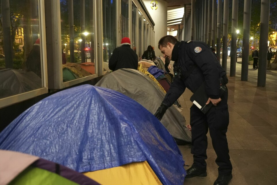 En politimann sjekker innom et telt i en migrantleir i Paris tirsdag morgen. En politimann sjekker innom et telt i en migrantleir i Paris tirsdag morgen. Foto: Nicolas Garriga / AP / NTB