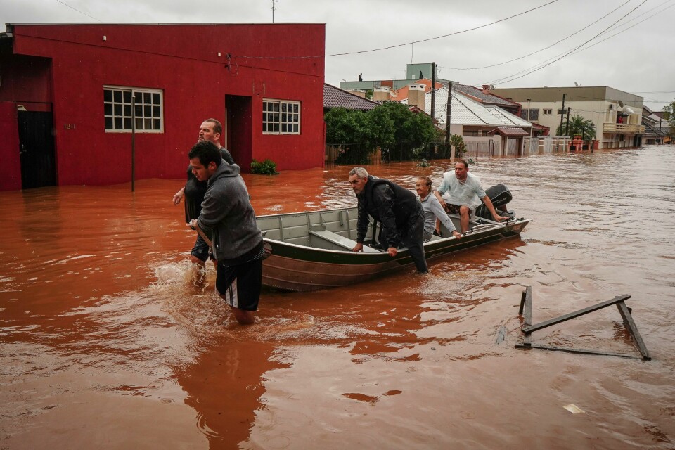 Folk blir reddet fra et flomrammet område i Sao Sebastiao do Cai i delstaten Rio Grande do Sul. Folk blir reddet fra et flomrammet område i Sao Sebastiao do Cai i delstaten Rio Grande do Sul. Foto: Carlos Macedo / AP / NTB