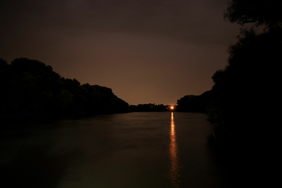 Tisza har vist seg å være vanskelig å krysse for folk på flukt fra Ukraina. Lights shine at night on the Tisza River near Tiszaroff, Hungary, Tuesday, Aug. 1, 2023. Since its start in 2013, participants in the annual Plastic Cup competition — which offers a prize for those who collect the most trash each year — have gathered more than 330 tons (around 727,000 pounds) of waste from the Tisza and other Hungarian waters. (AP Photo/Denes Erdos)