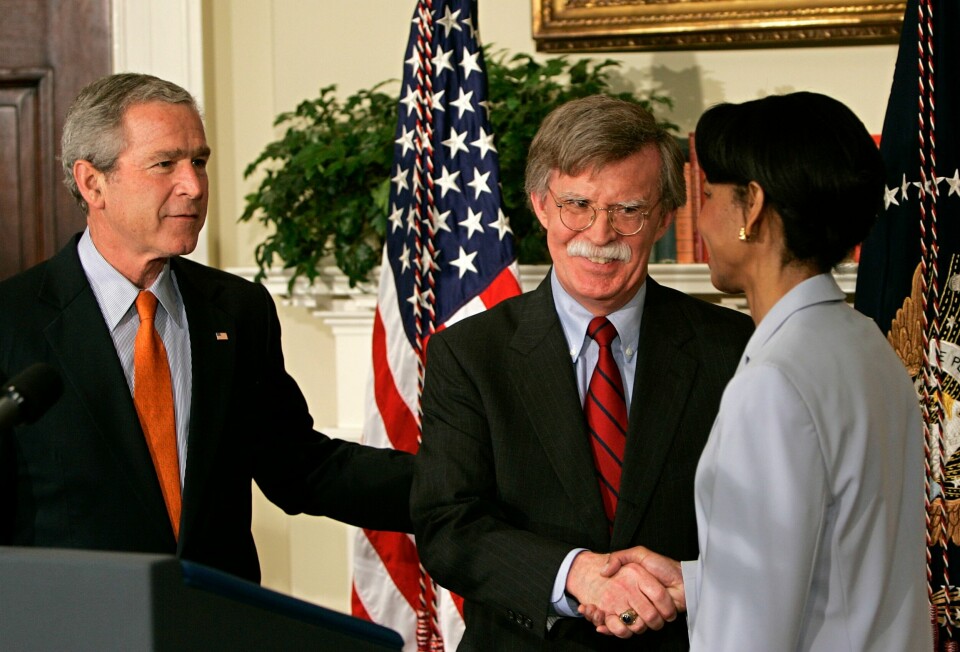 John Bolton (midten) avbildet med tidligere president George W. Bush og tidligere utenriksminister Condoleezza Rice tilbake i 2005. John Bolton (C) is congratulated by US Secretary of State Condoleezza Rice (R) after being installed by President George W Bush (L) as the permanent Ambassador to the United Nations for the US in the Roosevelt Room of the White House 01 August, 2005 in Washington, DC. Bolton has faced harsh criticism by oppenets, and pledged to work for a 'stronger, more effective' United Nations while promoting US interests and values at the world body. Bolton, 56, said he would work tirelessly to advance the agenda of President George W. Bush, who appointed him to the post by decree after his confirmation vote in the US Senate was blocked for months. AFP PHOTO/Brendan SMIALOWSKI
