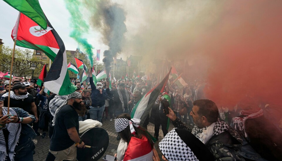 Røyksignaler i palestinske farger spredte seg over torget i Malmö under demonstrasjonen. Røyksignaler i palestinske farger spredte seg over torget i Malmö under demonstrasjonen. Foto: Martin Meissner / TT / NTB.