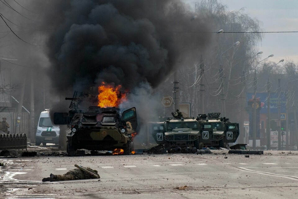 Bilde fra Russlands angrep i Kharkiv-området i 2022, da fullskala-invasjonen startet. FILE - An armored personnel carrier burns next to damaged and abandoned Russian light utility vehicles in Kharkiv, Ukraine, Feb. 27, 2022, three days after Russia invaded Ukraine. (AP Photo/Andrew Marienko, File)
