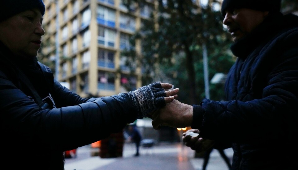En kunde overrekkes en kopp varm kaffe av en selger i Santiago fredag, der temperaturene har falt kraftig de siste dagene. En kunde overrekkes en kopp varm kaffe av en selger i Santiago fredag, der temperaturene har falt kraftig de siste dagene. Foto: Esteban Felix / AP / NTB