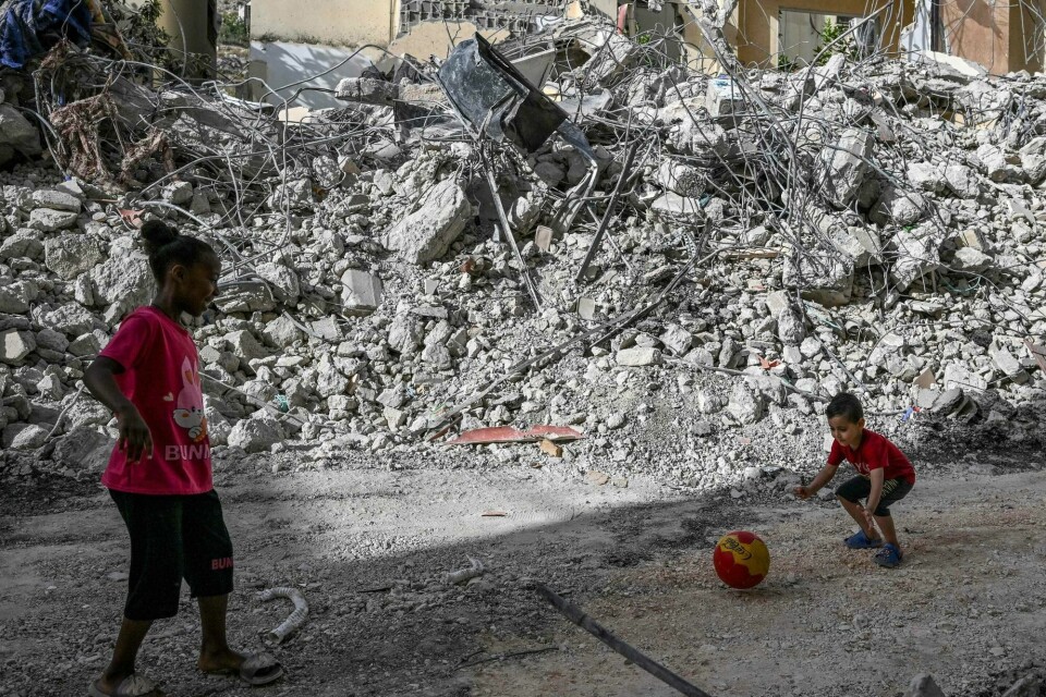 Palestinske barn spiller fotball foran et ødelagt hus i Jenin på Vestbredden. Huset ble ødelagt i et israelsk angrep. Verdensbanken advarer nå mot økonomisk kollaps på Vestbredden. A Palestinian boy plays with a friend in front of a destroyed house in Jenin in the aftermath of a raid by Israeli forces in the occupied West Bank city on May 23, 2024. Heavy fighting rocked the West Bank, where a two-day Israeli raid that began on May 21 morning in and around the city of Jenin has killed 11 people and wounded 25, according to the Ramallah-based Palestinian health ministry. (Photo by RONALDO SCHEMIDT / AFP)