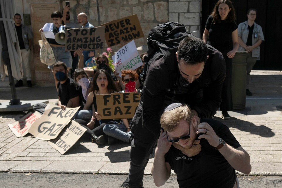 En israelsk politimann fjerner en aktivist fra inngangen til det amerikanske konsulatet i Jerusalem. Aktivistene krever at USA slutter å gi våpen til Israel som brukes i Gaza. En israelsk politimann fjerner en aktivist ved inngangen til en amerikansk konsulatbygning i Jerusalem, der israelske og amerikanske aktivister krevde at USA slutter å forsyne Israel med våpen til Gaza-krigen. Foto: Maya Alleruzzo / AP / NTB