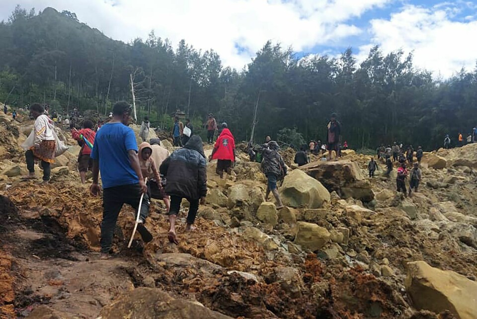 Over 2000 mennesker skal være begravet under jordmassene etter det store raset i Papua New Guinea fredag. Skredet rammet flere landsbyer i provinsen Enga rundt 600 km nordvest for hovedstaden Port Moresby. Folk på vei over skredet som kan ha kostet flere hundre mennesker livet i høylandet i Papua Ny-Guinea. Foto: Benjamin Sipa / International Organization for Migration / AP / NTB