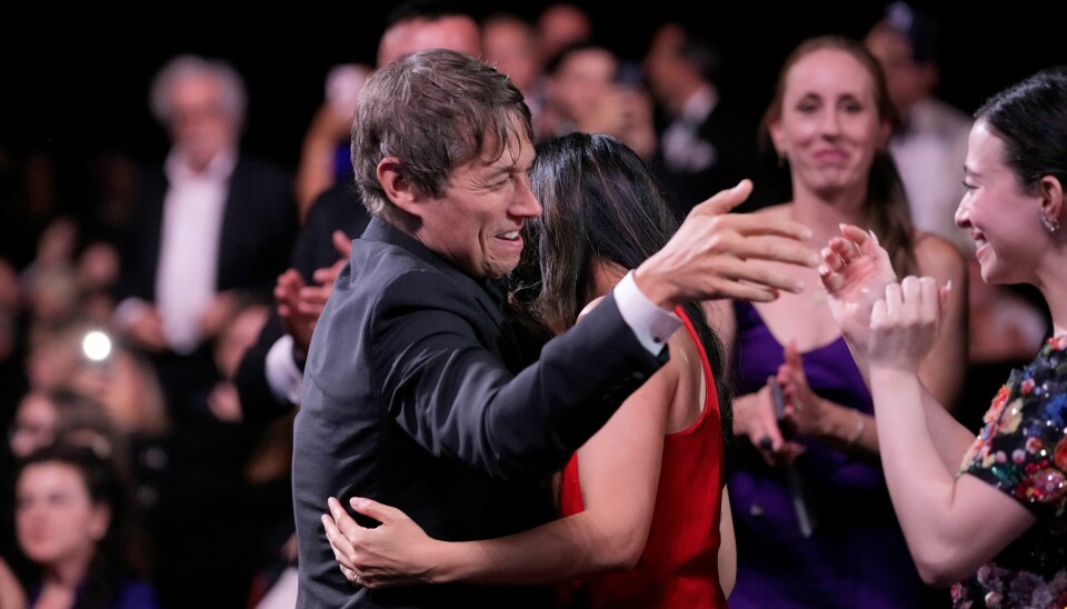 Sean Baker omfavnes på vei opp til scenen i Cannes i Sør-Frankrike lørdag kveld. Sean Baker omfavnes på vei opp til scenen i Cannes i Sør-Frankrike lørdag kveld. Foto: Andreea Alexandru/Invision/AP / NTB