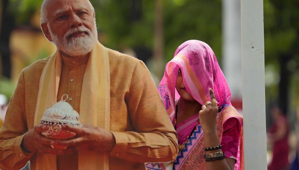 En kvinne viser fram fingeren som er farget av blekk, et tegn på at hun har avlagt sin stemme i det indiske valget. Ved siden av henne er et utskåret fotografi av Narendra Modi i helfigur. Han ligger an til å sikre seg en tredje periode som Indias statsminister. Bildet er tatt i Varanasi. En kvinne viser fram fingeren som er farget av blekk, et tegn på at hun har avlagt sin stemme i det indiske valget. Ved siden av henne er et utskåret fotografi av Narendra Modi i helfigur. Han ligger an til å sikre seg en tredje periode som Indias statsminister. Bildet er tatt i Varanasi. Foto: Rajesh Kumar Singh / AP / NTB