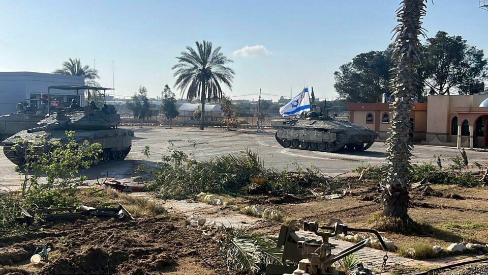 Et foto gitt ut av den israelske hæren IDF viser pansrede israelske kjøretøy på Gaza-siden av grenseovergangen Rafah mot Egypt den 7. mai. En stridsvogn med israelsk flagg kjører inn på den palestinske siden av Rafah-overgangen tirsdag. Foto: Det israelske forsvaret / AP / NTB
