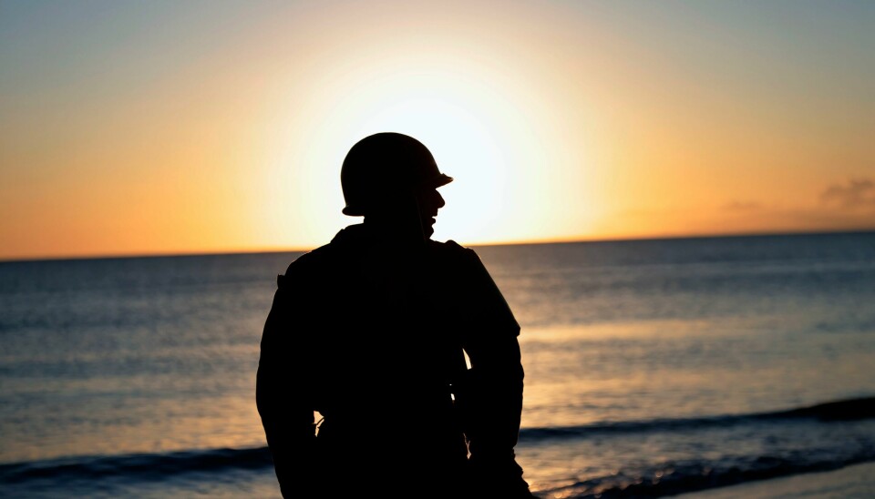 En mann i uniform avbildet i forbindelse med en markering på Omaha Beach i Saint-Laurent-sur-Mer i franske Normandie i 2022. A man in a vintage US WWII uniform walks at dawn on Omaha Beach in Saint-Laurent-sur-Mer, Normandy, France Monday, June 6, 2022, the day of 78th anniversary of the assault that helped bring an end to World War II. (AP Photo/Jeremias Gonzalez)