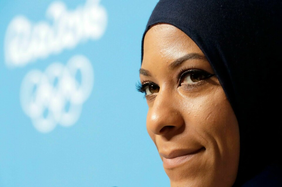 Å systematisk utestenge utøvere på bakgrunn av personlig tro og kulturell bakgrunn er hårreisende i 2024, mener forfatterne av innlegget. Bildet viser fekteren Ibtihaj Muhammad, som i OL i Rio i 2016 ble første amerikanske utøver til å konkurrere i hijab. Ibtihaj Muhammad, første amerikanske OL-utøver til å konkurrere i hijab. (2016)