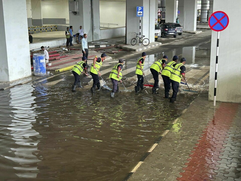 Arbeidere fjerner vann utenfor Indira Gandhi International Airport etter kraftig vind og nedbør i den indiske hovedstaden fredag morgen. Arbeidere fjerner vann utenfor Indira Gandhi International Airport etter kraftig vind og nedbør i den indiske hovedstaden fredag morgen. Foto: Shonal Ganguly / AP / NTB