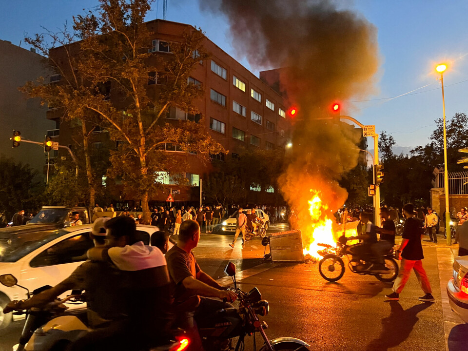 Det har vært flere dager med protester i Iran etter dødsfallet til Masha Amini. Her står en politi-motorsykkeli flammer under en protest i Irans hovedstad Teheran. En motorsykkel står i flammer under en protest i Irans hovedstad Teheran etter dødsfallet til Mahsa Amini.
