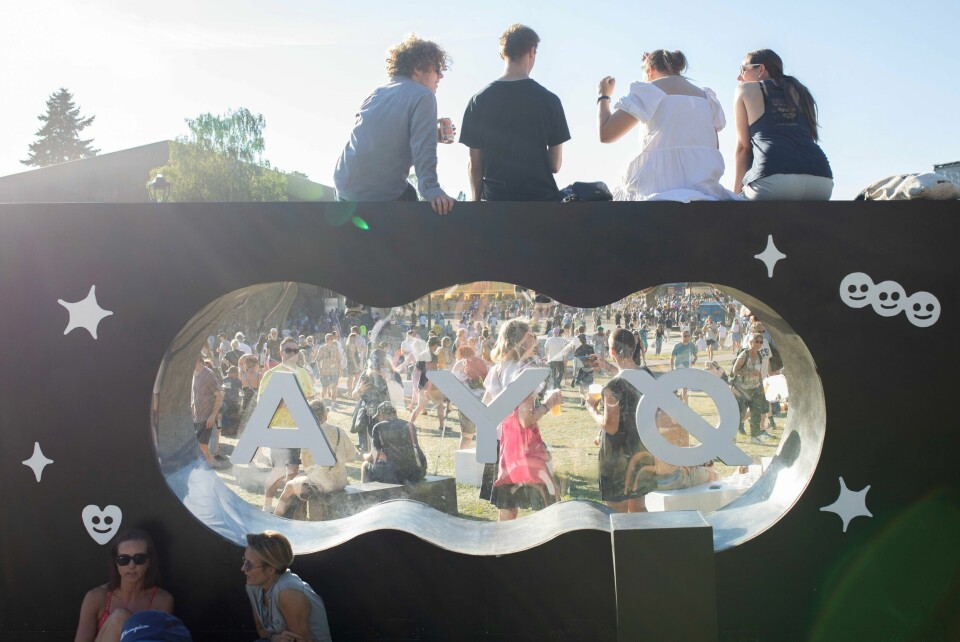 Fra Øyafestivalen 2022, som samlet over 20.000 hver dag gjennom fire dager i Tøyenparken Noen har klatra opp på logoen, andre sitter under.