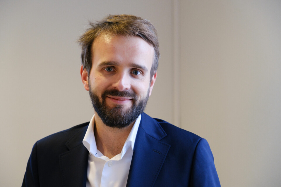 Næringsminister Jan Christian Vestre er stolt over den nye eierskapsmeldingen. Næringsminister Jan Christian Vestre smiler til kamera foran en hvit vegg.