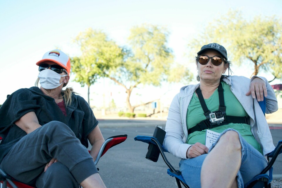Lynnette, 50, og Nicole, 52, overvåker en stemmeurne i Arizona - rundt 70 prosent av republikanske velgere tror valgresultatet i 2020 ble påvirket av stemmesvindel. To kvinner filmer velgere ved en stemmeurne i Arizona.