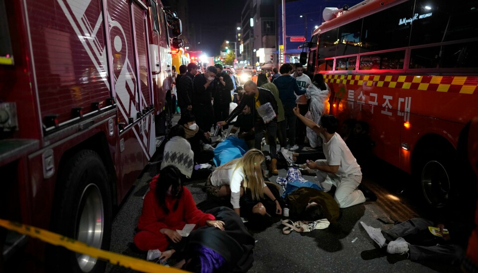 Skadde mennesker får hjelp i en av gatene i Seoul. Skadde mennesker får hjelp i en av gatene i Seoul. Mange er Injuried people are helped at the street near the scene in Seoul, South Korea, early Sunday, Oct. 30, 2022. South Korean officials said around 50 people were in cardiac arrest and a number feared dead after being crushed by a large crowd pushing forward on a narrow street during Halloween festivities in the capital Seoul. (AP Photo/Lee Jin-man)