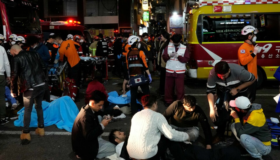 Over 150 mennesker døde da det oppsto trengsel under halloween-feiringen i Sør-Koreas hovedstad lørdag. Utenriksdepartementet bekrefter at det er en norsk borger blant de døde. Redningsarbeidere, brannmenn og forbipasserende jobber med å hjelpe skadde mennesker etter panikken i en trang gate under halloween-feiringen i Seoul. Foto: Lee Jin-man / AP / NTB