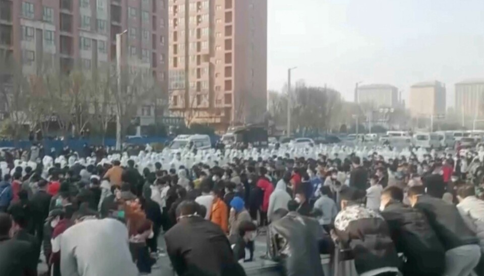Store deler av den kinesiske byen Zhengzhou blir stengt ned, dagen etter store demonstrasjoner ved den enorme Iphone-fabrikken som ligger der. Dette bildet AP har fått tak i, viser demonstranter i sammenstøt med sikkerhetspersonell i hvitt. Store deler av den kinesiske byen Zhengzhou blir stengt ned, dagen etter store demonstrasjoner ved den enorme Iphone-fabrikken som ligger der. Dette bildet AP har fått tak i, viser demonstranter i sammenstøt med sikkerhetspersonell i hvitt. Foto: AP / NTB