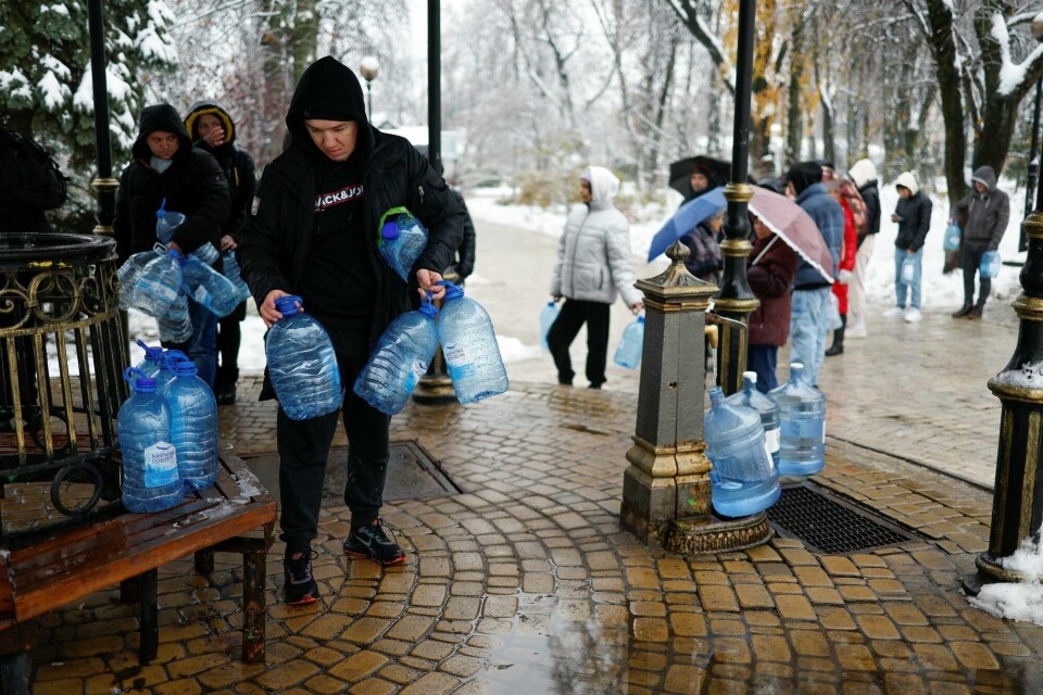 Innbyggere i Kyiv fyller opp dunker med vann etter at viktig infrastruktur ble rammet i angrepene onsdag. Både tilgangen på strøm og vann ble rammet. Innbyggere i Kyiv fyller opp dunker med vann etter at viktig infrastruktur ble rammet i angrepene onsdag. Både tilgangen på strøm og vann ble rammet.