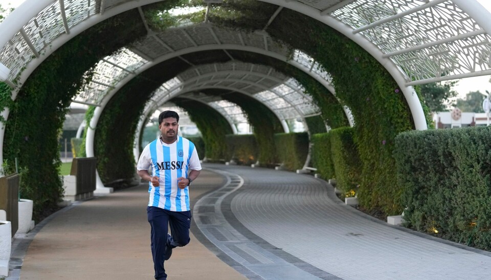 En Messi-fan jogger i parken Al Gharafa i Doha. Qatar kunngjorde i oktober i fjor en plan om å kutte utslippene med en firedel. Etter Russlands invasjon av Ukraina har Qatars flytende naturgass blitt enda mer ettertraktet. Etterspørselen etter fossilt brensel har skapt stor velstand i Qatar, men i framtiden kan det også gjøre et av verdens varmeste steder ubeboelig. En Messi-fan jogger i parken Al Gharafa i Doha. Qatar kunngjorde i oktober i fjor en plan om å kutte utslippene med en firedel. Etter Russlands invasjon av Ukraina har Qatars flytende naturgass blitt enda mer ettertraktet. Etterspørselen etter fossilt brensel har skapt stor velstand i Qatar, men i framtiden kan det også gjøre et av verdens varmeste steder ubeboelig. Foto: Abbie Parr / AP / NTB