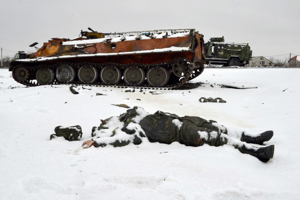 En russisk soldat ligger død ved et militærkjøretøy utenfor Kharkiv et par dager etter invasjonen av Ukraina i februar 2022. .
