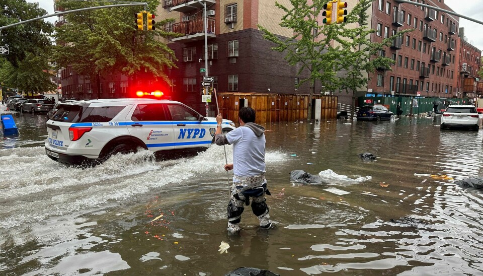 En arbeider prøver å rense et avløp mens flomvannet stiger i gatene i Brooklyn, New York fredag. En arbeider prøver å rense et avløp mens flomvannet stiger i gatene i Brooklyn, New York fredag. Foto: Jake Offenhartz / AP / NTB