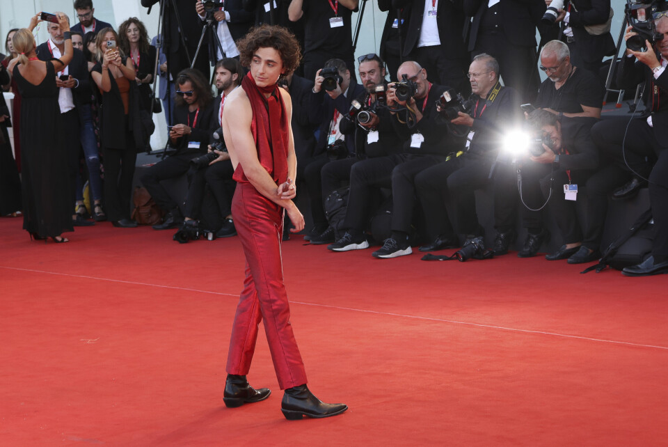 En stilsikker Timothee Chalamet med rød dress og bar rygg. En stilsikker Timothee Chalamet med rød dress og bar rygg.