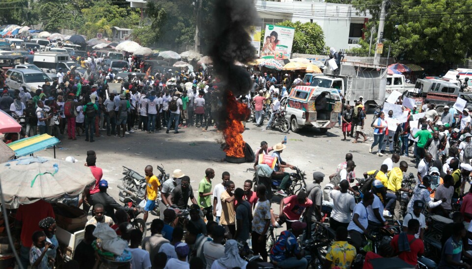 FNs sikkerhetsråd ga mandag grønt lys til å sende en styrke for å bekjempe gjengvolden i Haiti. Haitiere demonstrerer mot usikkerheten i Port-au-Prince. Foto: Odelyn Joseph / AP / NTB