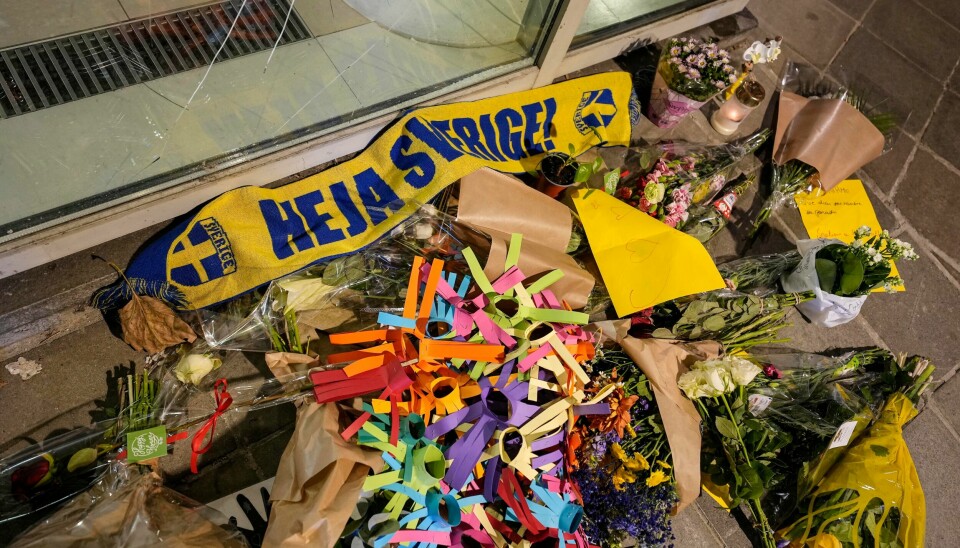 Blomster og et svensk fotballflagg nedlagt i området i Brussel der to svensker ble drept mandag kveld. Blomster og et svensk supporterskjerf lagt ned der to svensker ble skutt i Brussel mandag. Svenske idrettsfolk kan få råd om å unngå bruk av lett gjenkjennelige klær og effekter, som blågult landslagstøy. Foto: Martin Meissner, AP / NTB