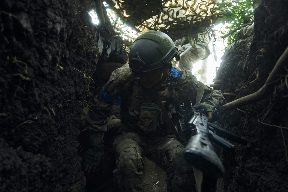 En ukrainsk soldat søker dekning i nærheten av Bakhmut i Øst-Ukraina nylig. Russland gikk til fullskala invasjon av Ukraina i februar 2022. En ukrainak soldat i en skyttergrav utenfor Bakhmut mandag denne uken. Myndighetene melder at det er gjort framskritt i kampene mot russerne. Foto: Libkos / AP / NTB