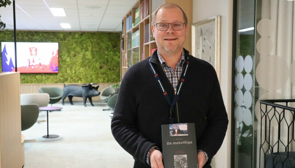 Kristian Ilner har akkurat utgitt boken 'De motvillige' som handler om regimemotstand som fenomen i fortid og nåtid. Kristian Ilner står med boken i hendene og ser veldig glad ut.
