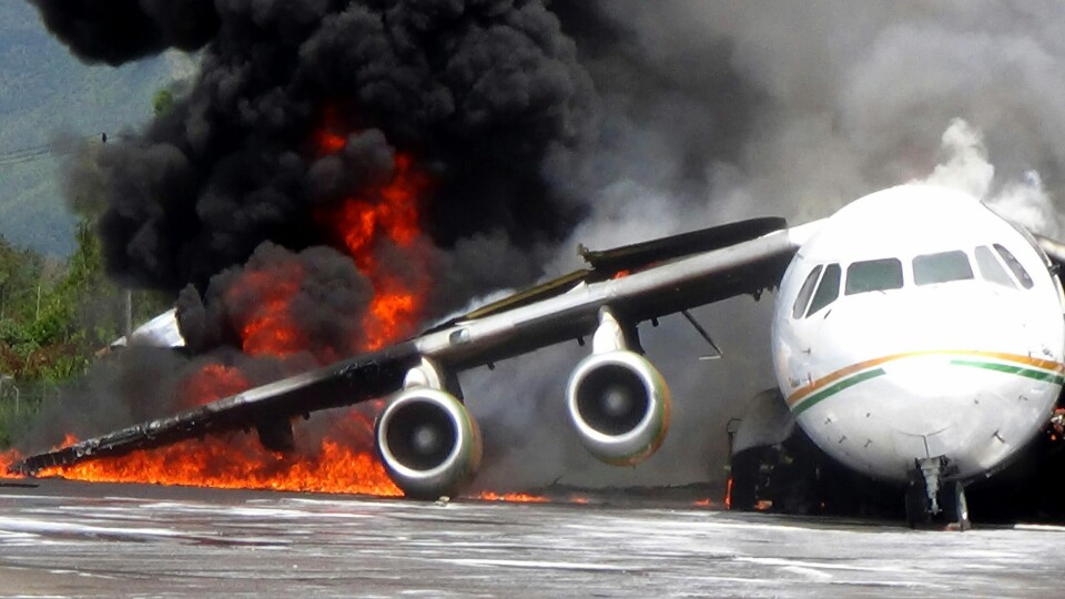 Norge har vært skånet for store flybranner etter at røykdykkertjenesten ved landets flyplasser ble endret. Her fra en flybrann i Indonesia i 2013. Smoke billows from a British-made BAe 146 cargo plane that caught fire while being unloaded at the airport in Wamena, Papua province, Indonesia, Wednesday, May 8, 2013. An official said that the plane caught fire after a drum of oil fell from the aircraft and somehow sparked the fire. (AP Photo)