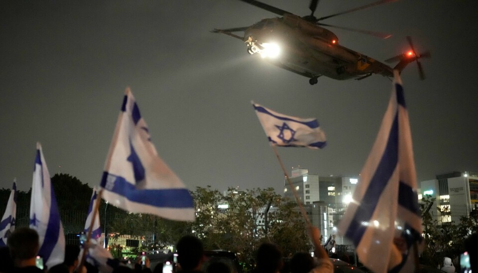Flere møtte opp med israelske flagg da et helikopter med gisler som Hamas har holdt ganget på Gazastripen, ankom Israel søndag. Flere møtte opp med israelske flagg da et helikopter med gisler som Hamas har holdt ganget på Gazastripen, ankom Israel søndag. Foto: Leo Correa / AP / NTB