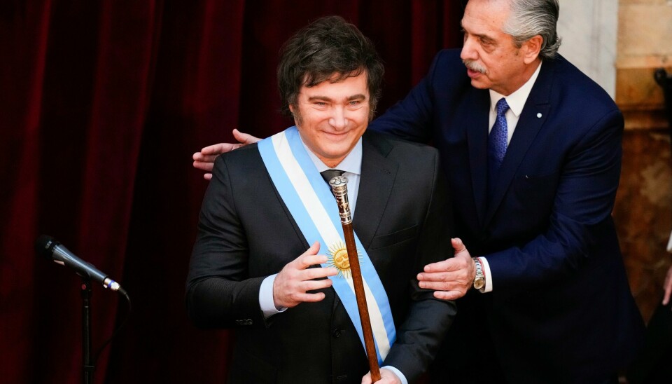 Avtroppende president Alberto Fernandez (til høyre) ga den nye presidenten en klapp på skulderen da Milei ble tatt i ed. Foto: Natacha Pisarenko / AP / NTB