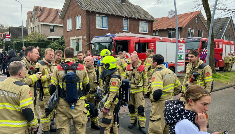 Brannmannskaper ventet lørdag formiddag nær utestedet der en mann, som angivelig var utstyrt med våpen og sprengstoff, holdt et ukjent antall gisler i Ede i Nederland. Brannmannskaper ventet lørdag formiddag nær utestedet der en mann, som angivelig var utstyrt med våpen og sprengstoff, holdt et ukjent antall gisler i Ede i Nederland. Foto AP / NTB