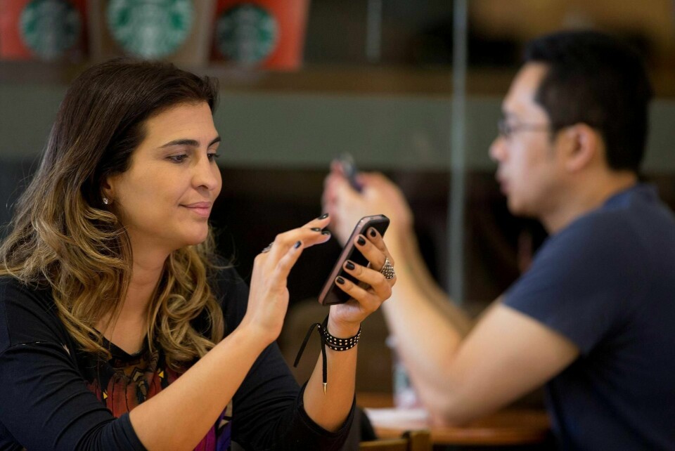 MOBILBRUK: En kvinne sjekker mobiltelefonen sin på en kafé i São Paulo i Brasil. Storavisen Folha har forsøkt å tilbakevise falske Whatsapp-meldinger i valgkampen i Brasil, uten resultat, folk trodde mer på meldingene fra venner og kjente enn avisens nyhet om at meldingene var falske, skriver Benedicte Bull. FOTO: ANDRE PENNER/NTB SCANPIX