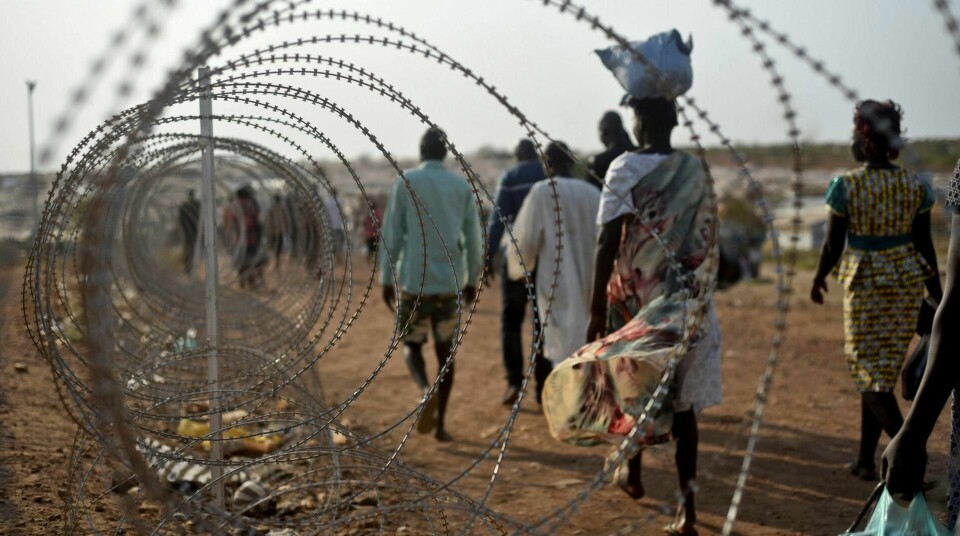 VOLDTEKT SOM VÅPEN: Flyktninger går forbi et piggtrådgjerde utenfor FNs base i Juba. Voldtekt er en sentral del av krigføringen i Sør-Sudan. FOTO: JASON PATINKIN/NTB SCANPIX